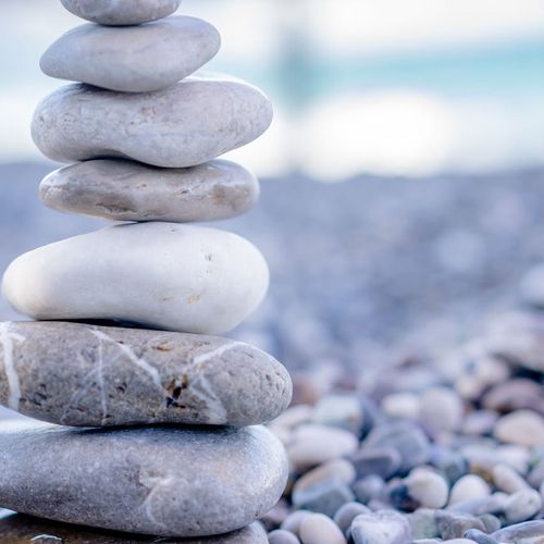 Stack of smooth stones balanced on a serene beach.