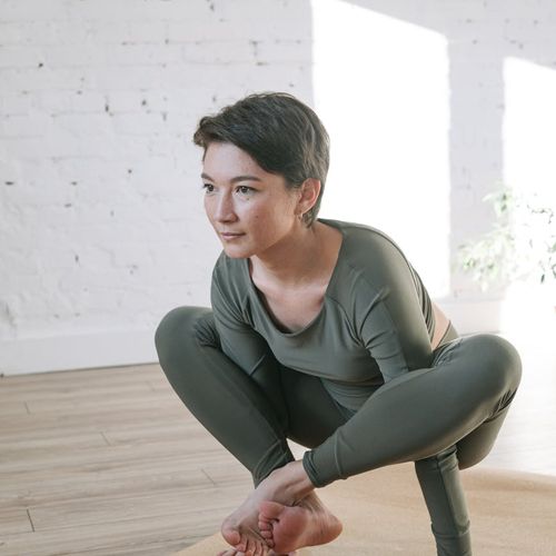 Woman meditating peacefully in a bright, sunlit room.